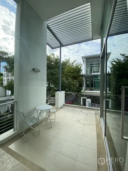 Townhouse for rent or sale in Chatuchak, Bangkok - Upper-floor terrace with roof slats, outdoor seating and neighborhood view.