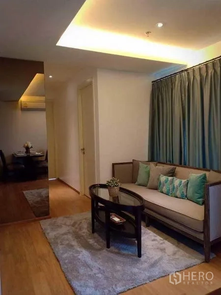 คอนโด ให้เช่าในWatthana, Bangkok - ห้องนั่งเล่นพร้อมโซฟา พรม และฝ้าซ่อนไฟ ข้างผ้าม่านทึบ