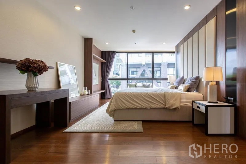 Condominium for sale in Sathon, Bangkok - Master suite showing desk and TV console facing floor-to-ceiling glass.