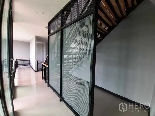 โรงงาน ให้เช่าหรือขาย - บันไดสไตล์ลอฟท์ โครงเหล็กกั้นตาข่าย พื้นกระเบื้องเงาในโซนออฟฟิศ