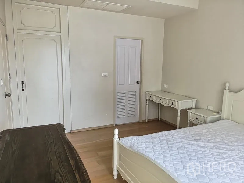 Condominium for rent or sale in Phaya Thai, Bangkok - Bright bedroom with white furniture, built-in wardrobe and wood floors.