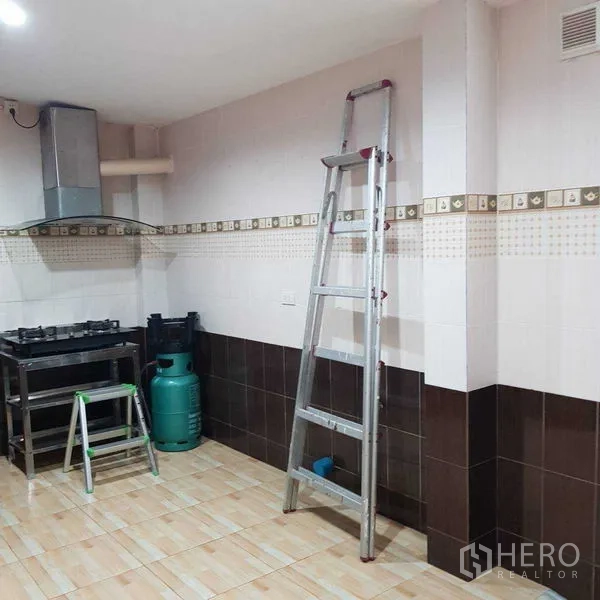 Home Office for rent in Watthana, Bangkok - Practical Thai kitchen with gas stove, range hood and tiled walls.