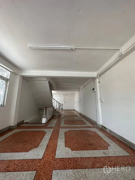 Shophouse for rent in Bangkok - Long open-plan corridor-style floor with ceiling lights and stairway.
