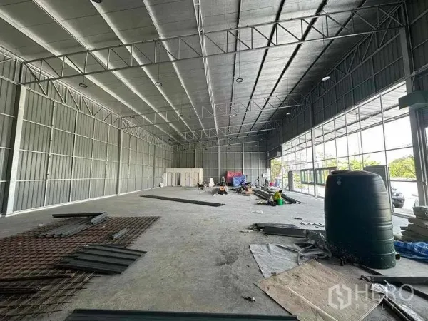 货栈 出租在Pak Kret, Nonthaburi - 仓库内部：高挑保温屋顶、钢结构、混凝土地面以及办公室/卫生间区。