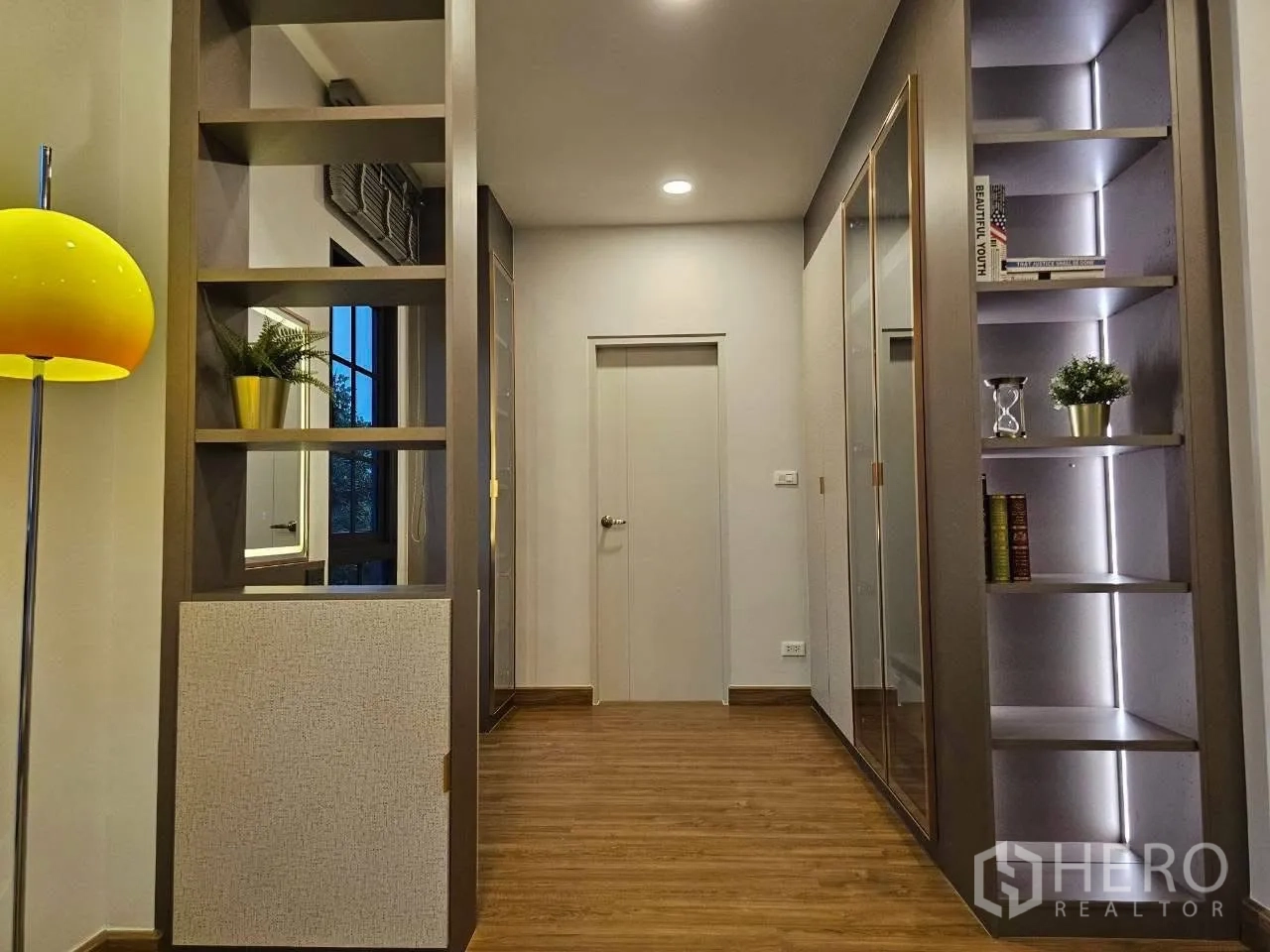 Detached House for rent or sale in Bang Phli, Samut Prakan - Hallway with illuminated built-in shelving and mirrors.