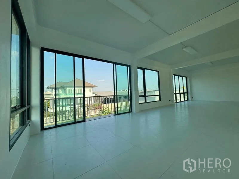 Home Office for rent in Don Mueang, Bangkok - Sunlit corner room with wide sliding glass panels and balcony access.