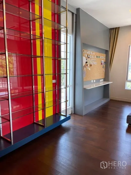 Detached House for rent in Bang Phli, Samut Prakan - Accent shelving with red and yellow panels next to a study nook and cork board.