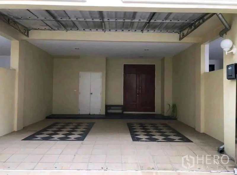 Townhouse for rent in Phra Khanong, Bangkok - Covered two-car carport with tiled floor, storage closet and double entry door.