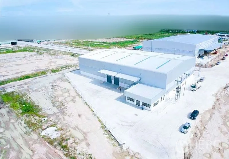 货栈 出租在Mueang Rayong, Rayong - 斜俯视图：仓库配宽阔混凝土场地，临道路出入口，周边为工厂区