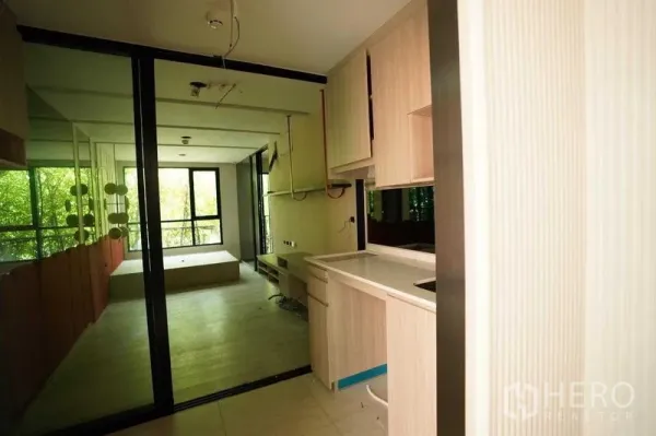 Standalone for rent in Bang Na, Bangkok - Compact pantry and work area with light wood cabinetry and a glass partition.