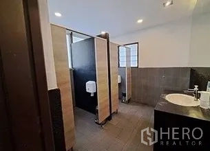 Retail Space for rent in Bangkok - Restroom area featuring multiple stalls, tiled walls, and a single-sink vanity.