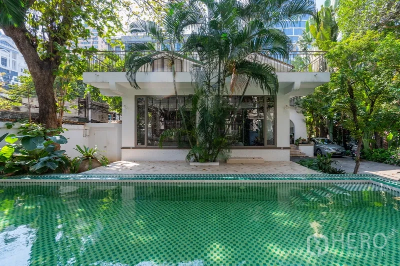 独立式住宅 出租在Pathum Wan, Bangkok - 私人绿色马赛克泳池，热带花园与现代白色外立面。