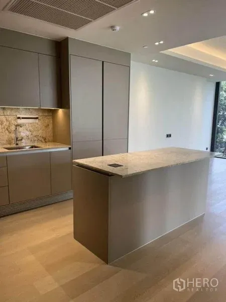Condominium for rent in Pathum Wan, Bangkok - Modern kitchen with stone-topped island and matte gray cabinetry in a Pathum Wan condo.