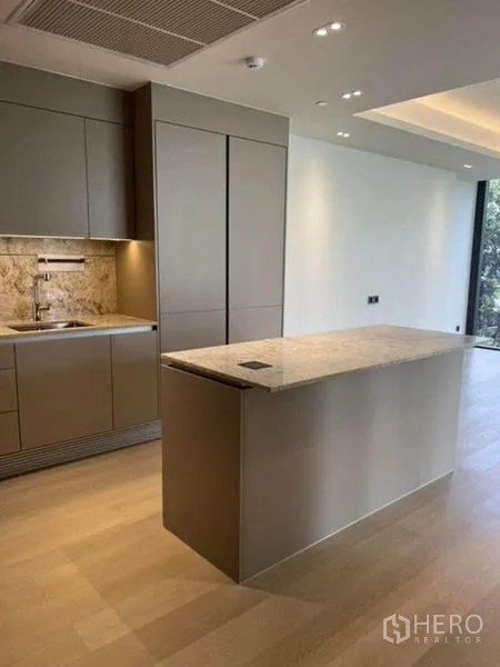 Condominium for rent in Pathum Wan, Bangkok - Modern kitchen with stone-topped island and matte gray cabinetry in a Pathum Wan condo.