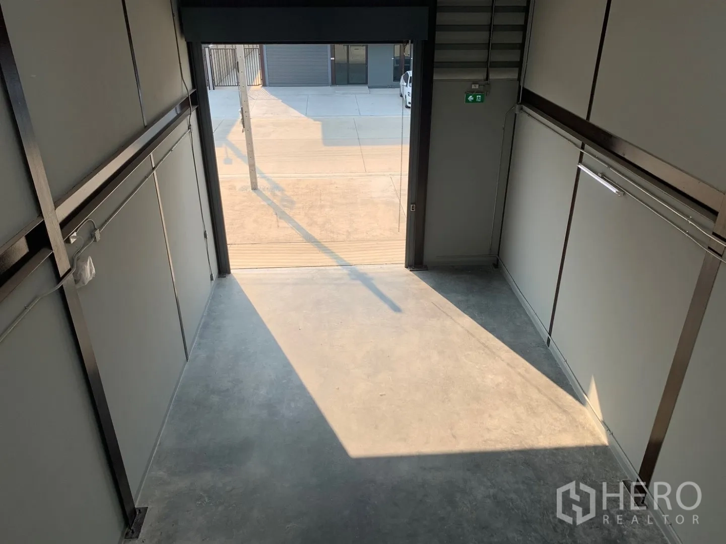 Warehouse for rent in Bang Phli, Samut Prakan - Inside the loading area looking toward the roller shutter and driveway.