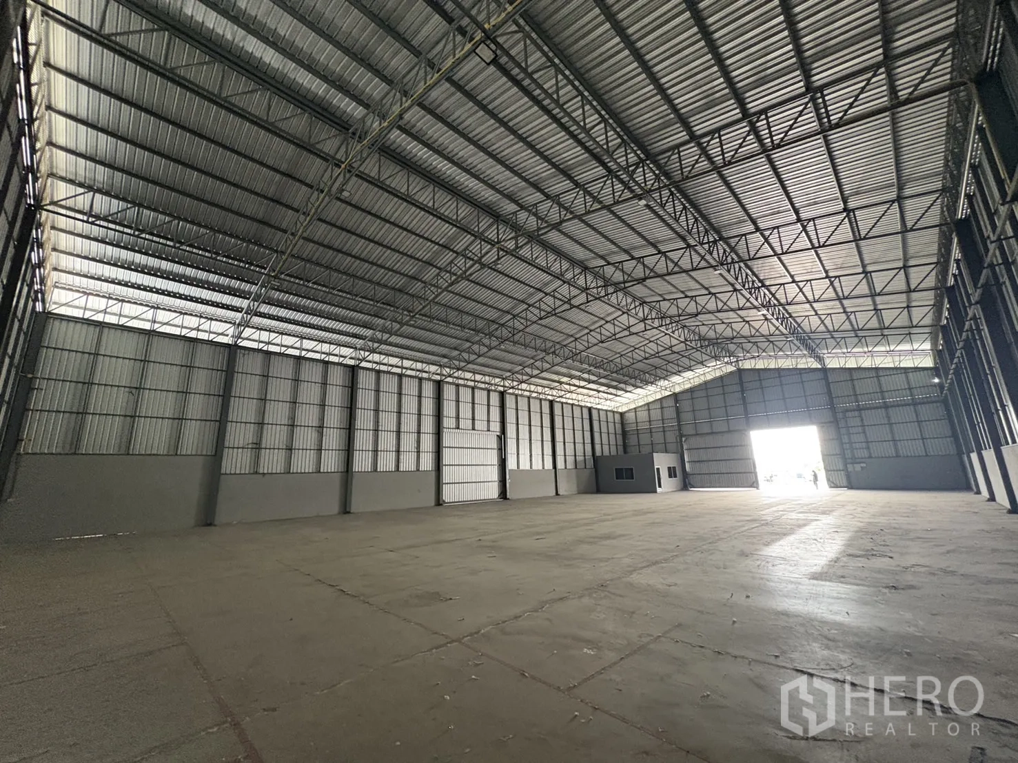 Warehouse for rent in Mueang Samut Prakan, Samut Prakan - Warehouse interior facing the bright entrance with internal office cabin and broad access opening.
