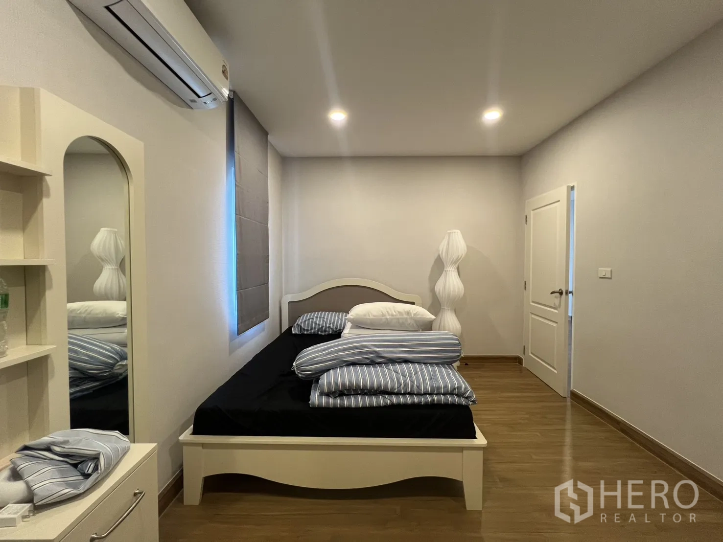 独栋房屋 for rent in Lat Krabang, Bangkok - 卧室角度展示床、落地灯与白色房门。