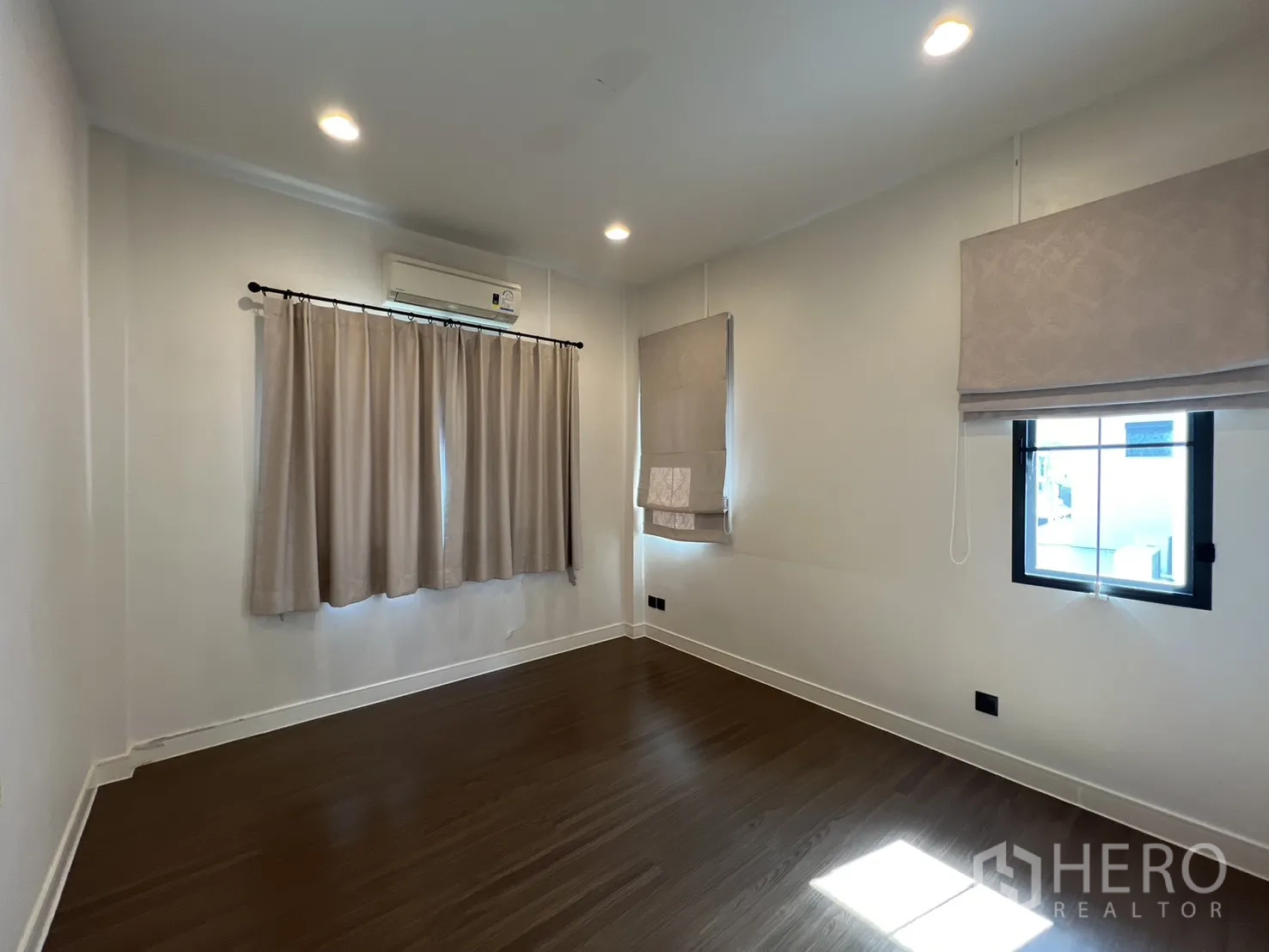 Detached House for sale in Bang Kapi, Bangkok - Spacious bedroom with multiple windows and curtains.