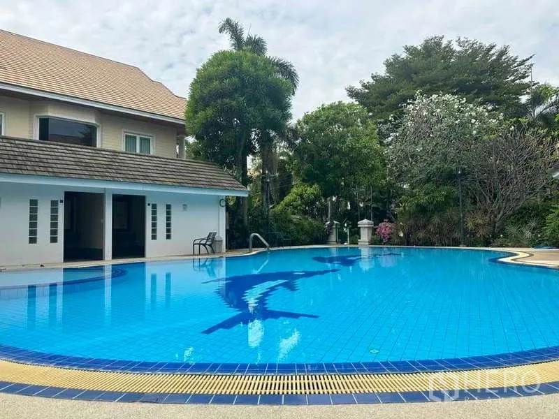 独立式住宅 出售在Suan Luang, Bangkok - 小区泳池与会所，周围环绕热带树木。