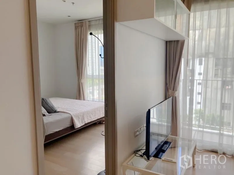 คอนโด ให้เช่าในWatthana, Bangkok - มุมมองจากห้องนั่งเล่นสู่ห้องนอน พร้อมหน้าต่างสูงและชั้นวางทีวี