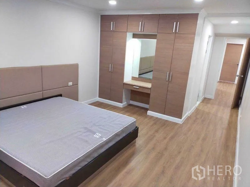 คอนโด ให้เช่าในWatthana, Bangkok - มุมห้องนอนเห็นเตียง โถงทางเดินยาว และตู้บิลต์อินพร้อมโต๊ะเครื่องแป้งกระจก