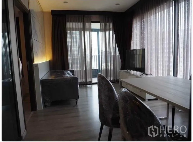 คอนโด ให้เช่าในHuai Khwang, Bangkok - ห้องนั่งเล่นหน้าต่างเต็มบาน เชื่อมระเบียง พร้อมทีวีและโต๊ะทานอาหาร