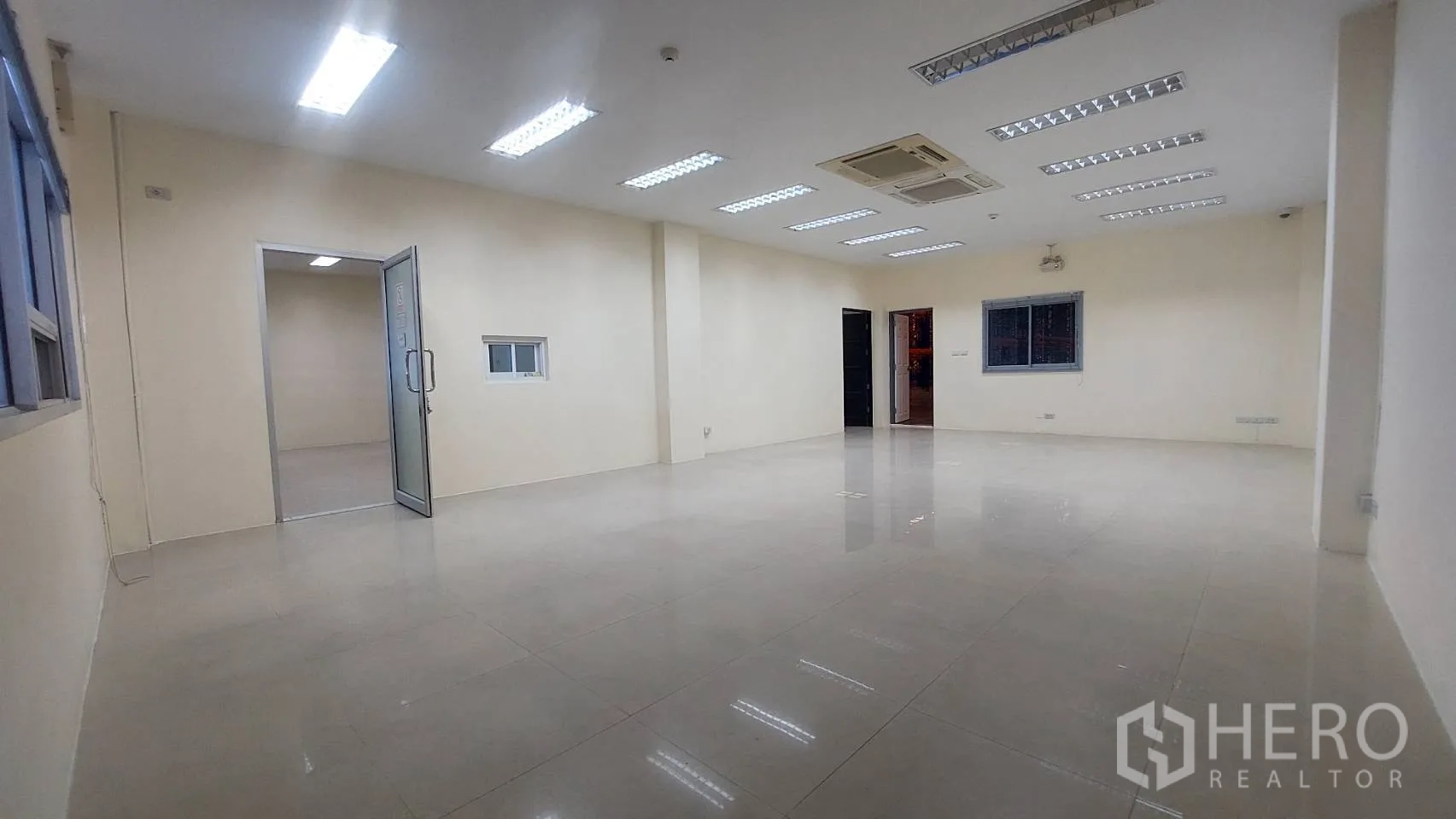 Warehouse for rent in Mueang Pathum Thani, Pathum Thani - Bright tiled office room with ceiling lights and air conditioning inside the warehouse.