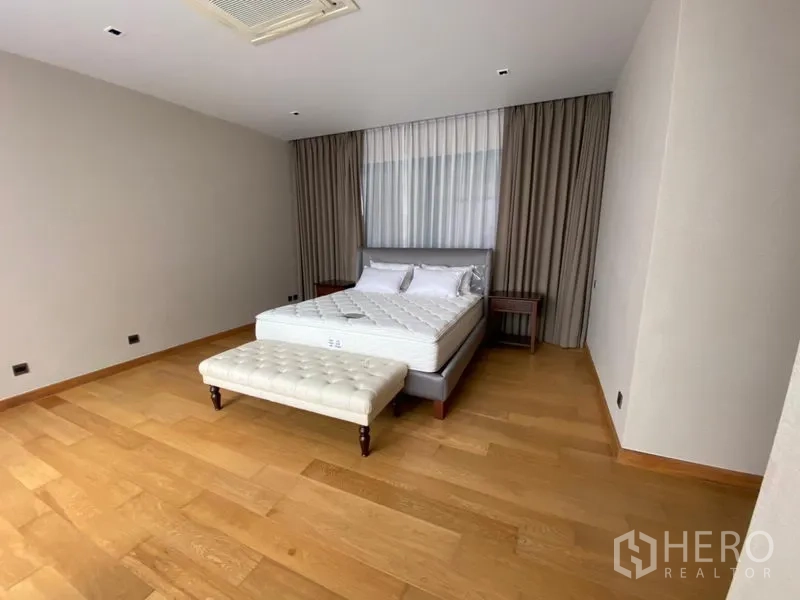 บ้าน ให้เช่าในHuai Khwang, Bangkok - มุมมองอีกด้านของห้องนอน เตียงใหญ่พร้อมเบนช์ ผ้าม่านและพื้นไม้โทนอุ่น
