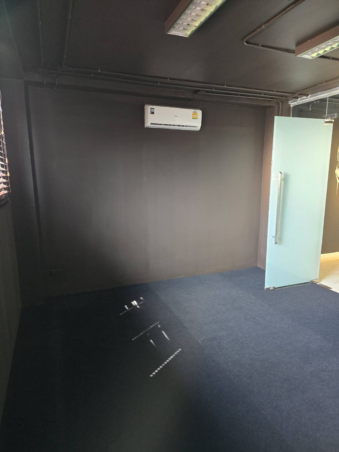办公空间 出租在Watthana, Bangkok - 私密房间，深色墙面与空调及玻璃门，适合作为经理室或安静办公区。