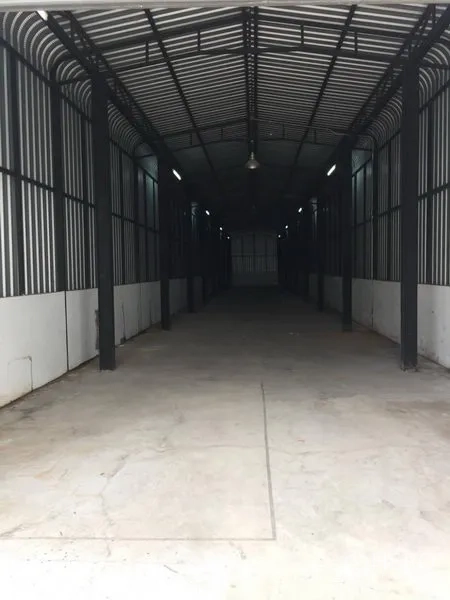 带办公室的家 出租或出售在Wang Thonglang, Bangkok - 仓库内部狭长空间，拱形钢结构屋顶与混凝土地面。