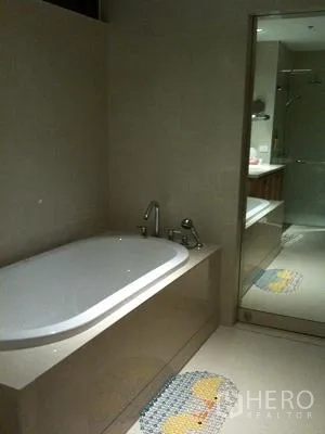 Condominium for rent or sale in Khlong Toei, Bangkok - Modern bathroom featuring a built-in bathtub and glass-enclosed shower.
