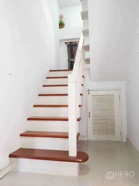 Detached House for sale in Nonthaburi - White staircase with wooden treads and an under-stair storage cupboard.