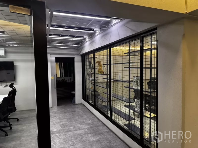 Office Space for rent or sale in Suan Luang, Bangkok - Office area with mesh feature wall, grid ceiling and enclosed meeting space.