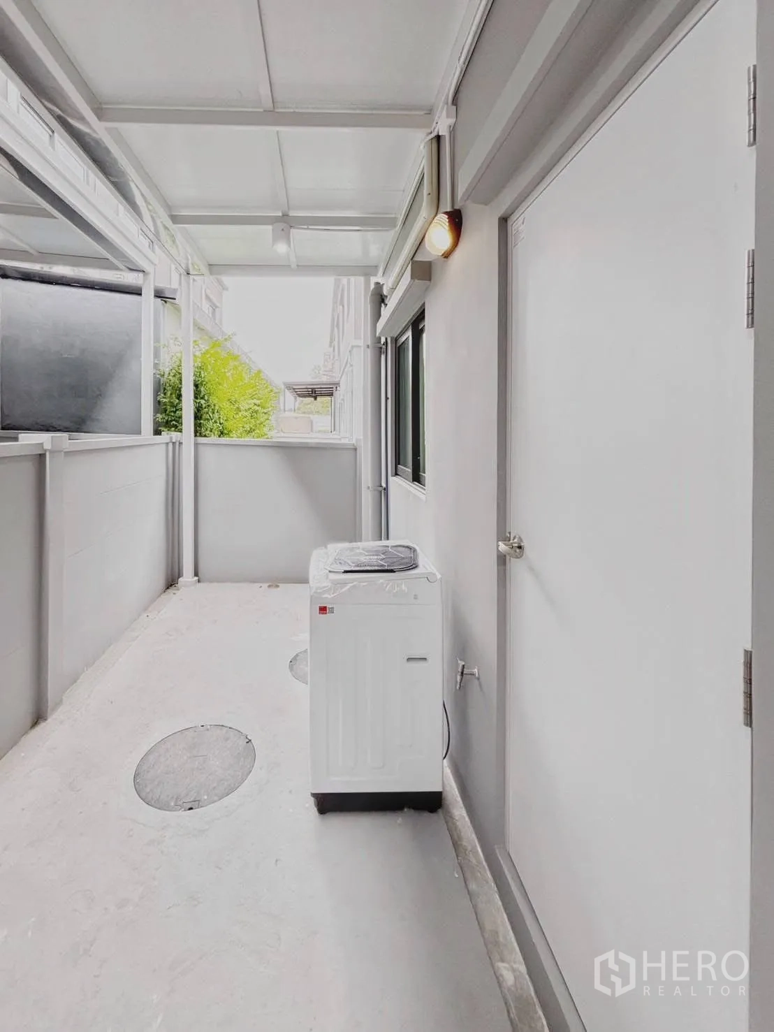Townhouse for rent in Bang Phli, Samut Prakan - Covered rear utility area with washing machine and external door.
