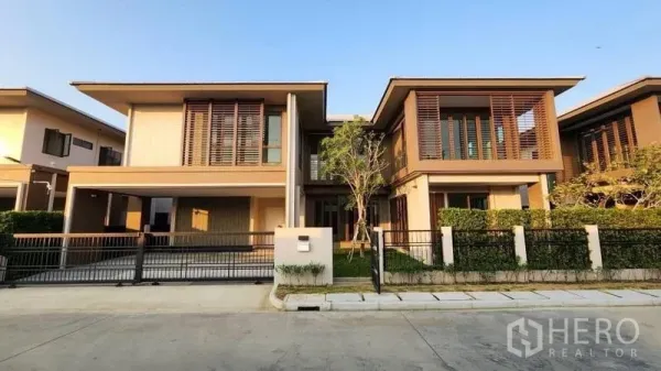 独立式住宅 出租或出售在Bang Kapi, Bangkok - 房屋正立面再现，两层住宅，车棚与修剪整齐的绿篱。