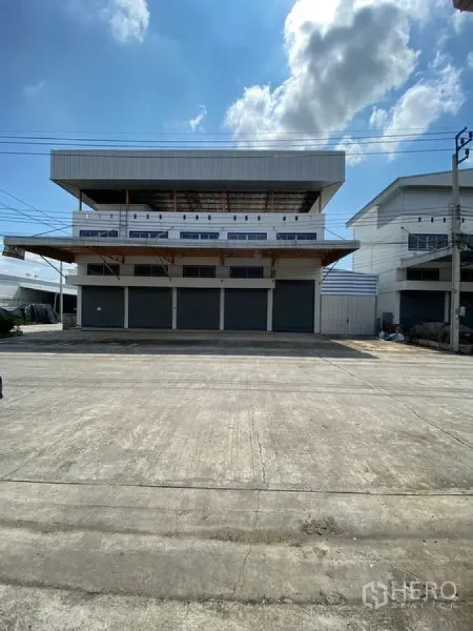 คลังสินค้า ให้เช่าหรือขายในBang Phli, Samut Prakan - มุมหน้าตัวอาคารโกดังหลายชั้นในบางพลี มีประตูม้วน 4 ช่องและลานคอนกว้าง