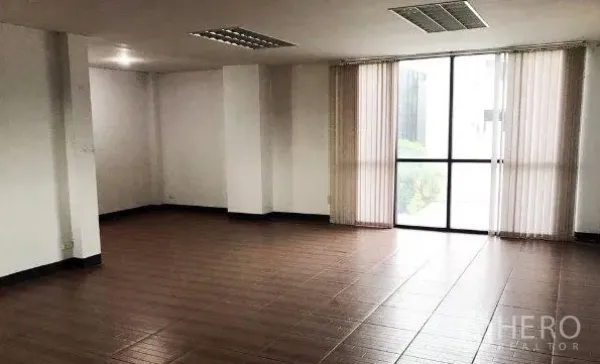 Office Space for rent or sale in Don Mueang, Bangkok - Spacious workspace with wood-look tile flooring and floor-to-ceiling window with vertical blinds.