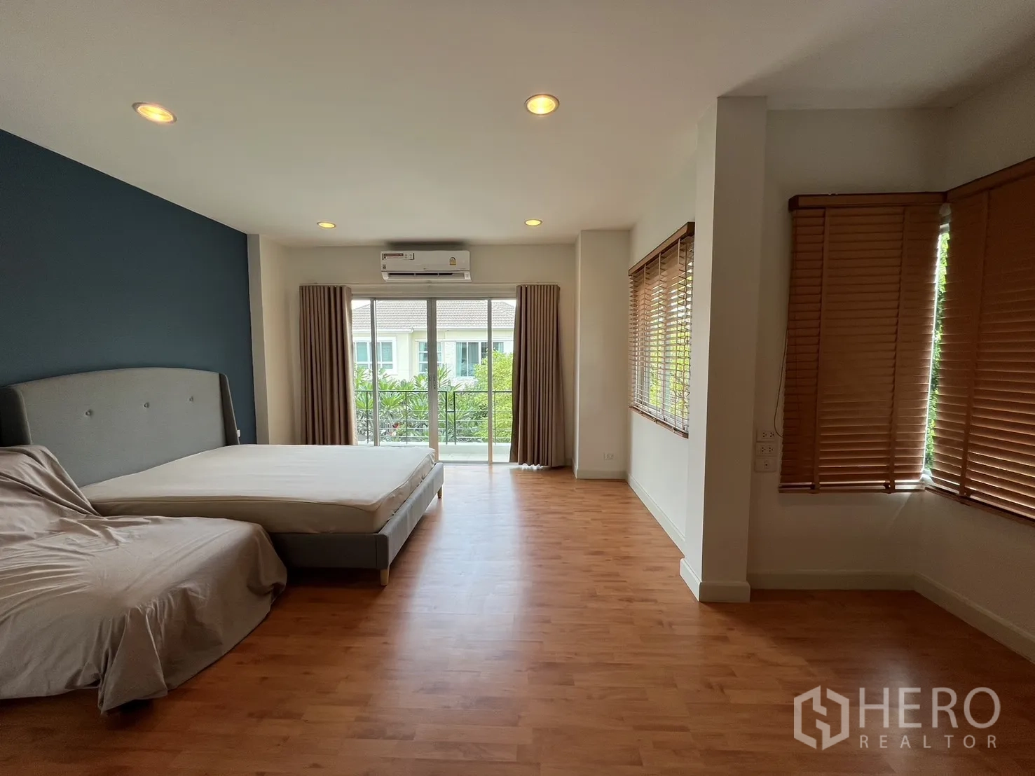Detached House for rent in Saphan Sung, Bangkok - Bright bedroom with wood floor, window and air conditioning.