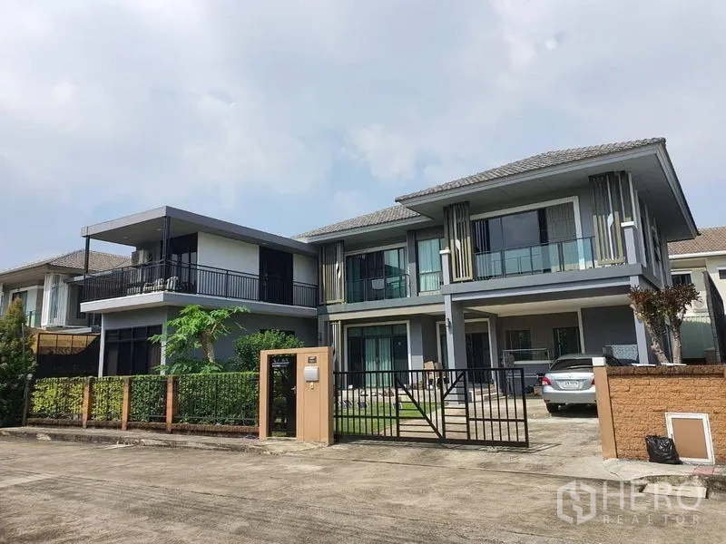 บ้าน ขายในSuan Luang, Bangkok - บ้านเดี่ยวสองชั้นสไตล์โมเดิร์น มีกำแพงรั้ว โรงจอดรถ และระเบียงกระจก ในชุมชนเงียบสงบของกรุงเทพฯ