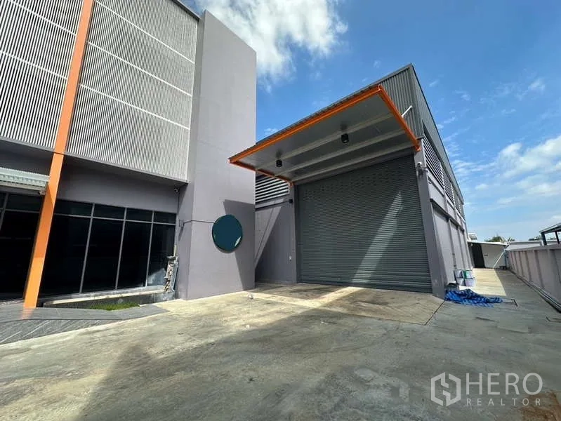 工厂 出租在Lam Luk Ka, Pathum Thani - 带雨棚的装卸区，卷帘门与宽阔的混凝土平台，紧邻办公楼