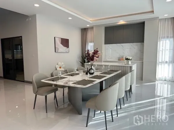 Detached House for rent or sale in Bang Phli, Samut Prakan - Spacious dining area beside a sleek island kitchen with marble finishes.