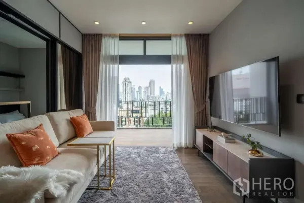 คอนโด ให้เช่าหรือขายในWatthana, Bangkok - ห้องนั่งเล่นสว่างพร้อมระเบียงและวิวสกายไลน์ที่ MUNIQ สุขุมวิท 23