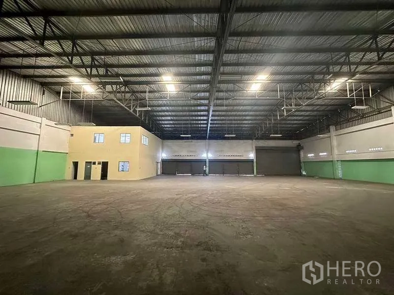 Factory for rent in Nonthaburi - Central view toward loading doors and the internal two-storey office inside the warehouse.