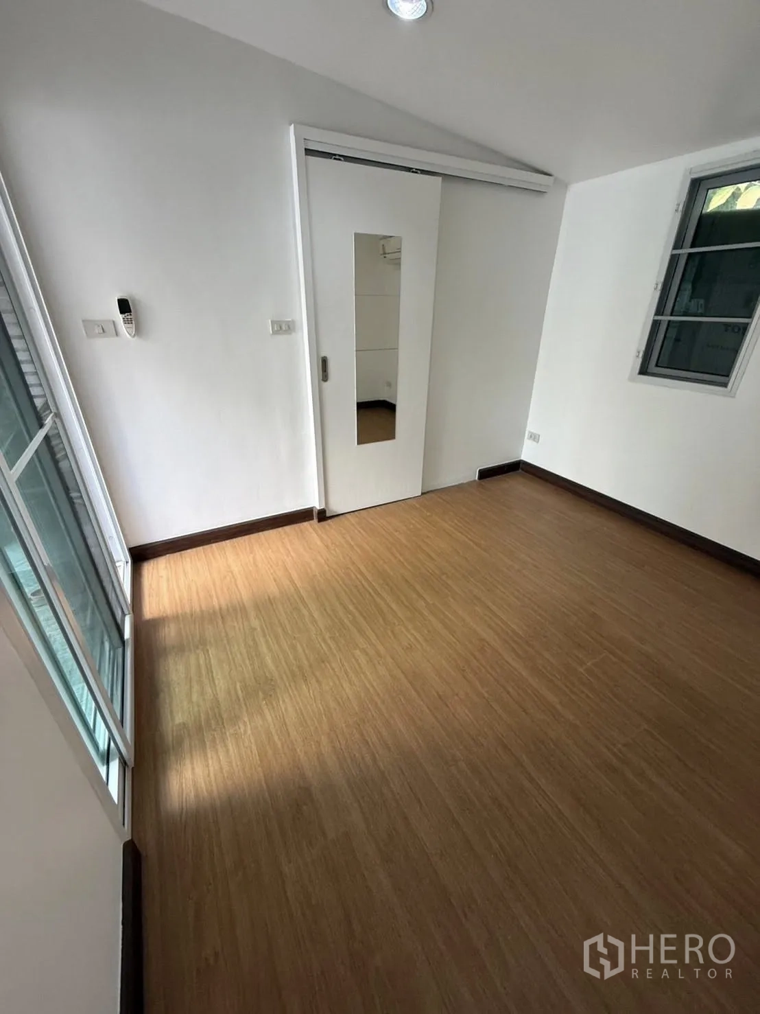 独栋房屋 for rent in Khlong Toei, Bangkok - 卧室铺木纹地板，带镜面推拉门与窗户。