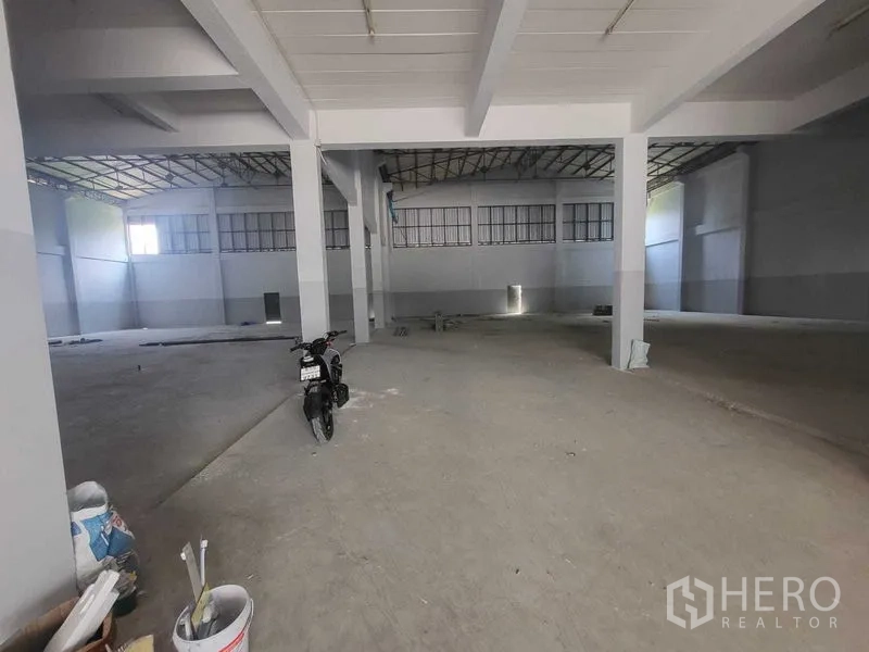 Factory for rent or sale in Samut Prakan - Wide factory interior with supporting columns and high side windows.