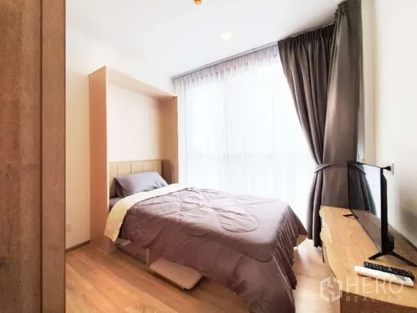 公寓 出售在Watthana, Bangkok - 次卧配床、遮光窗帘以及木柜上的电视。