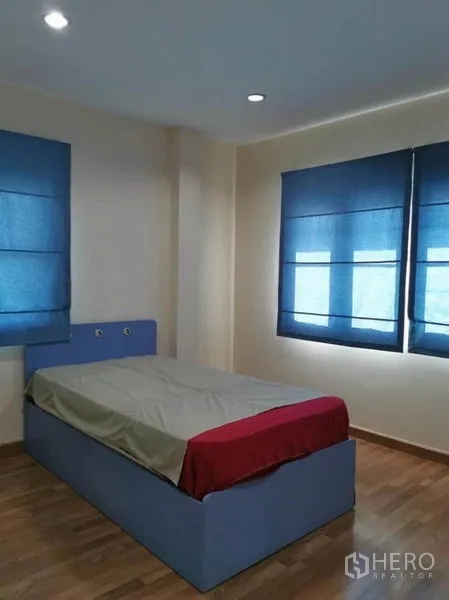 บ้าน ให้เช่าในBang Kapi, Bangkok - ห้องนอนเดี่ยว หน้าต่างมุมห้อง ม่านสีน้ำเงิน และพื้นไม้ รับแสงได้ดี