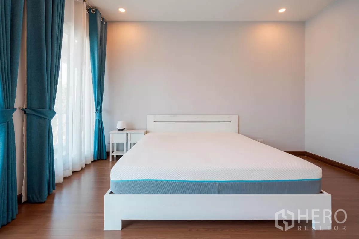Detached House for sale in Saphan Sung, Bangkok - Spacious master bedroom with large bed, wood flooring and floor-to-ceiling windows.