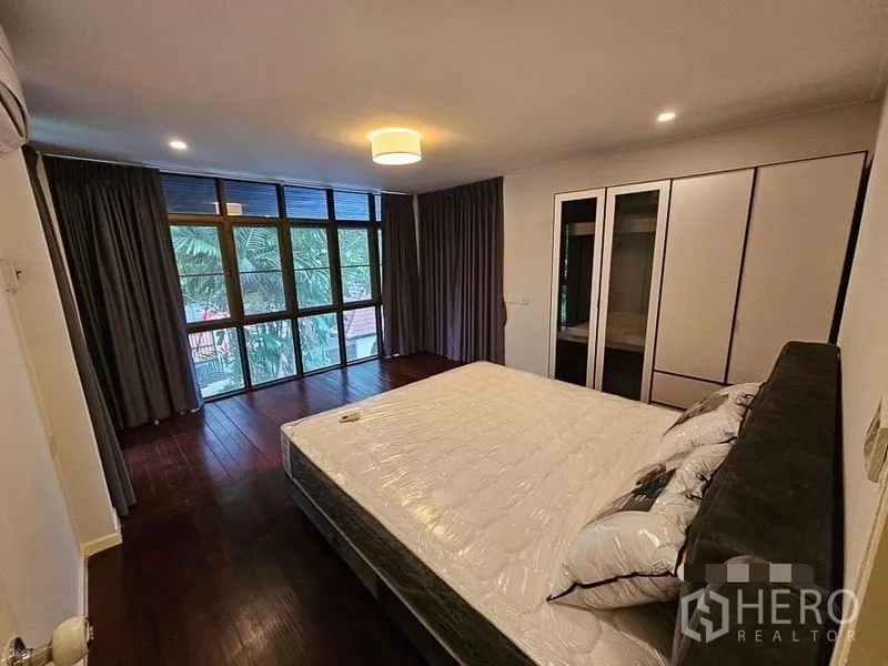 บ้าน ให้เช่า - ห้องนอนมีหน้าต่างบานใหญ่ ผ้าม่านทึบ และตู้เสื้อผ้าบิวท์อิน
