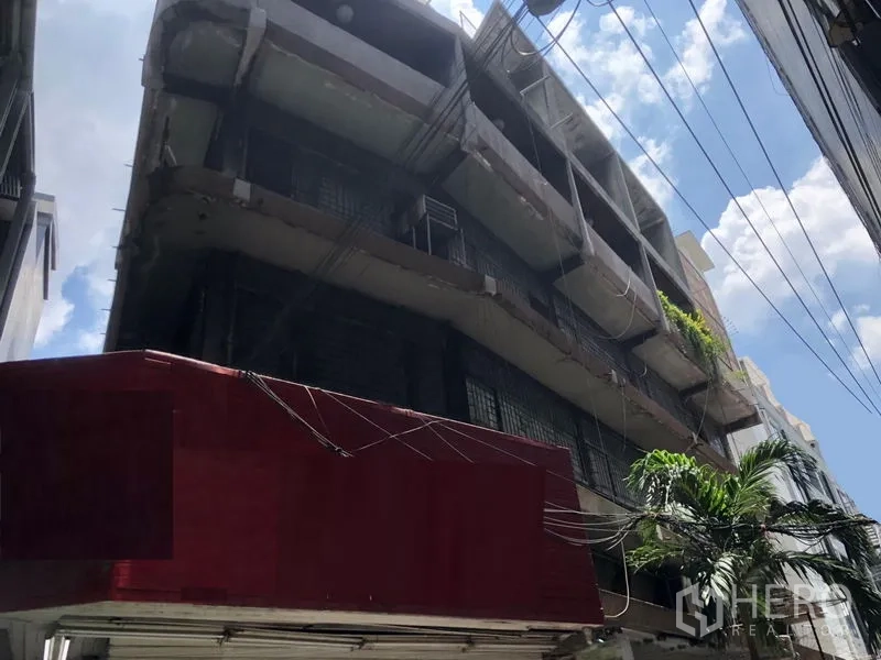 Shophouse for rent in Khlong Toei, Bangkok - Multi-storey shophouse exterior on a narrow lane with projecting balconies.